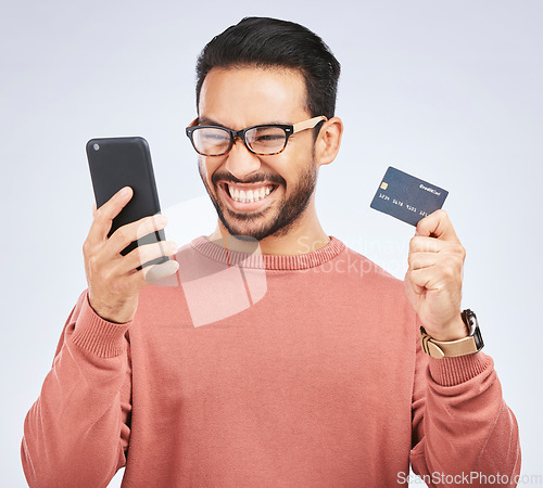 Image of Man is excited, smartphone and credit card, online shopping bonus with discount or promo on studio background. Positive customer experience, ecommerce and fintech, happy male person with sale and win