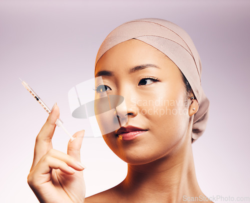 Image of Woman, face and plastic surgery with injection and studio background with asian for skincare. Female model, cosmetic and syringe for beauty, wellness and collagen for skin and closeup with filler.