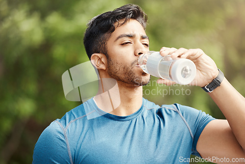 Image of Fitness, man with in park, drinking water and hiking in nature for health and wellness during exercise. Drink, bottle and fit male on hike with trees for body workout, energy and training mindset.