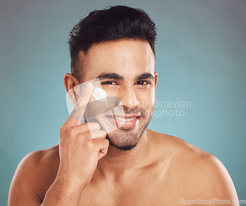 Image of Portrait, skincare and cream with a man in studio on a gray background to apply antiaging facial treatment. Face, beauty and lotion with a young male person indoor for wellness or aesthetic self care