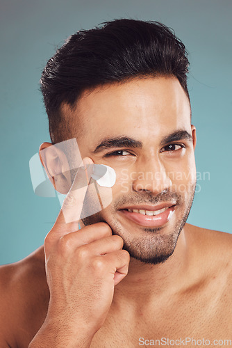 Image of Portrait, skincare and lotion with a man in studio on a gray background to apply antiaging facial treatment. Face, beauty and cream with a young male person indoor for wellness or aesthetic self care