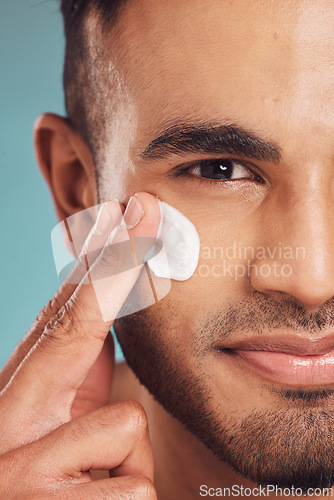 Image of Portrait, facial and lotion with a man in studio on a gray background to apply antiaging skincare treatment. Face, beauty or cream with a young male person applying spf sunscreen indoor for self care