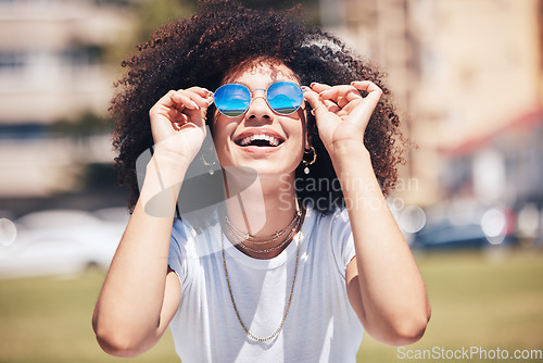 Image of Woman, fashion and sunglasses outdoor in city for happiness, summer and travel holiday. Face of african person with natural hair or afro at nature park with glasses and positive mindset for freedom