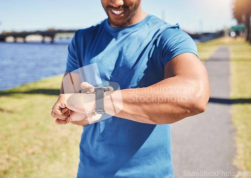 Image of Fitness, exercise and man with a watch outdoor for training or running progress at park. Smartwatch on arm of happy athlete person in nature with time to workout, start run and check performance goal