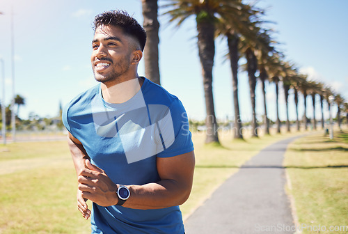 Image of Fitness, smile and a man or runner outdoor for exercise, training or running at a park. Happy Indian male athlete in nature for a workout, run and cardio performance with a watch for progress or goal