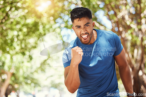 Image of Running, portrait and a man celebrate outdoor for exercise, training or fitness goals. Excited Indian male athlete with a fist in nature for a workout, run and performance target, success or win