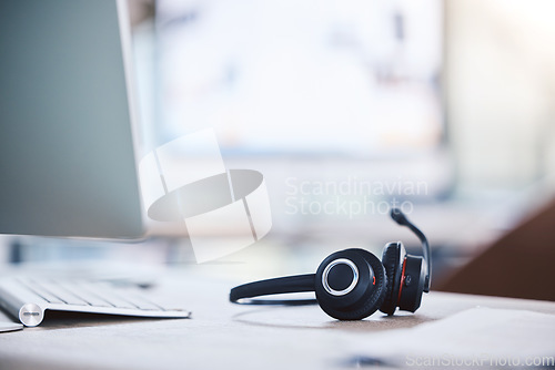 Image of Call center, customer service and headset and computer on a desk in an empty office space. Crm, telemarketing and sales or technical support company with headphones for help desk consultation