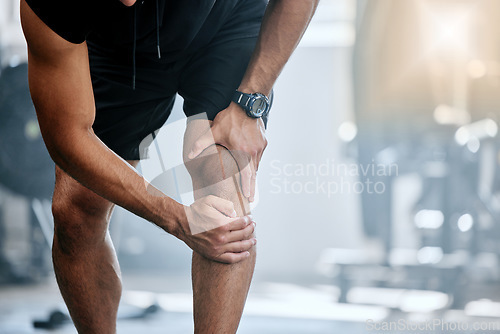 Image of Fitness, gym and mockup, man with knee pain and medical emergency from workout injury at sports studio. Exercise, health and wellness, bodybuilder with hand on leg muscle ache for relief at training.