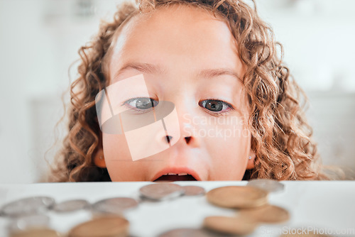 Image of Finance, surprise and coins with child at home for savings, money and budget. Growth, learning and cash with face of shocked girl and change on table for investment, profit or banking responsibility