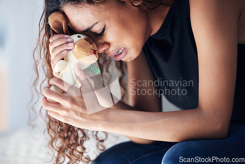 Image of Depression, tears and woman with teddy bear in home for grief, miscarriage or mourning death of kid. Sad mother, crying and person with pain, anxiety or trauma problem, stress or frustrated in house