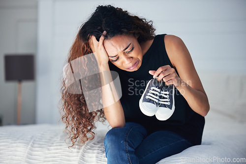 Image of Crying, depression and woman with shoes in bedroom for grief, miscarriage memory and mourn death of kid. Sad mother, tears and person on bed with pain, anxiety or trauma problem, stress or frustrated