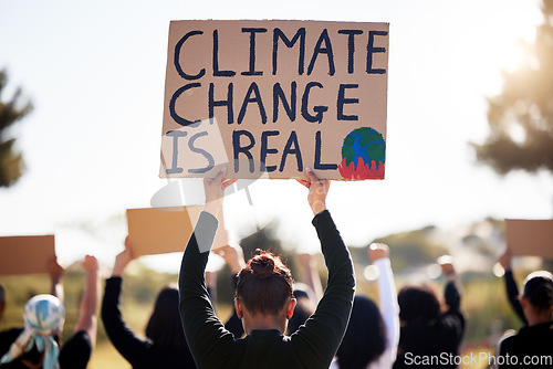 Image of Protest, global warming and sign with a group of people outdoor at a rally or march for conservation. Climate change, poster and environment with a crowd walking together during a community strike