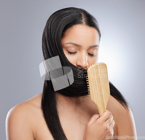 Image of Woman, brush and hair for salon, grooming or healthy style against a grey studio background. Calm female person or model in beauty or brushing for straight haircare and clean hygiene or treatment