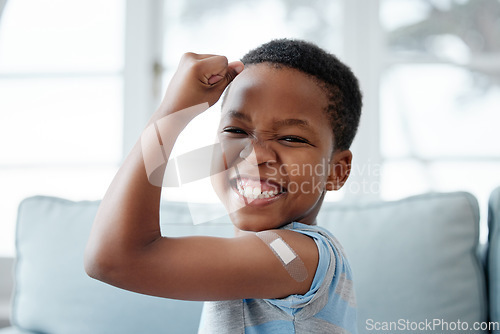 Image of African boy kid, vaccine and portrait with smile, medicine and flex muscle for wellness in hospital. Male child, strong and excited with plaster for injection, healthcare and injection to stop virus