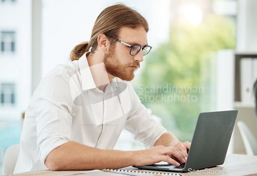 Image of Typing, laptop and business man in office for copywriting, company newsletter and research article or blog. Focus, working and social media writer, editor or person at startup, online and computer