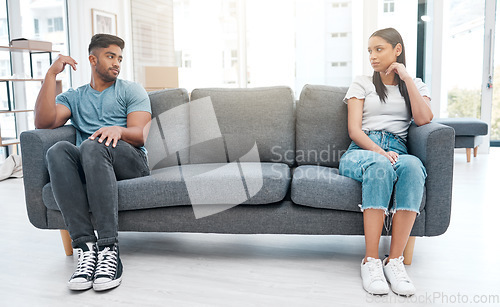 Image of Couple, fight and sofa distance feeling sad and depressed on living room with relationship problem. Divorce talk, cheating anxiety and marriage crisis of young people on a lounge couch at home