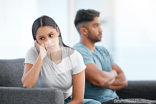 Image of Couple, fight and woman feeling sad and depressed on living room sofa with relationship problem. Divorce talk, cheating anxiety and marriage crisis of young people on a lounge couch at home thinking