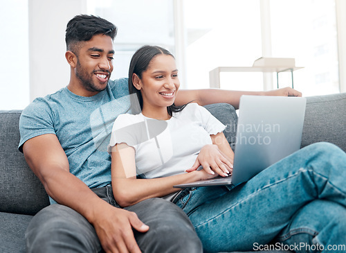 Image of Couple, laptop and watching a video on a lounge sofa with happiness and love at home. Computer, streaming series and young people together on a living room couch in a house with tech and a smile