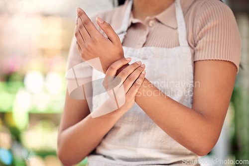 Image of Wrist pain, woman and closeup of hand, working and nursery for small business, gardening or problem. Girl, entrepreneur and arthritis in shop, store or joint injury with job at sustainable workplace