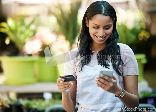 Image of Credit card, phone and a woman with a payment at a nursery for stock, plants or shopping on the web. Ecommerce, pay and a happy business owner or customer buying a plant on sale on a mobile app