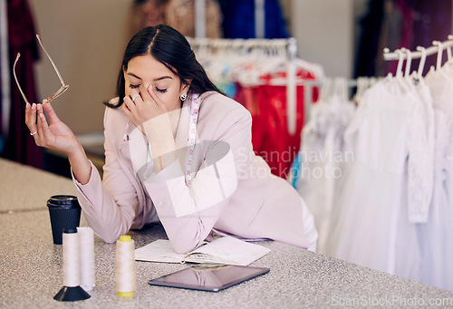 Image of Headache, tired and a fashion designer at a boutique for planning, burnout and sad from design fail. Stress, workshop and a woman with anxiety, fatigue or depression from working as a tailor