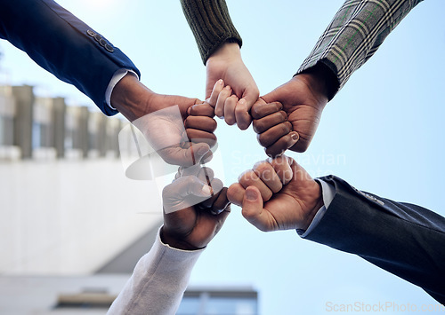 Image of Group, hands and fist pump together for celebration, collaboration or people in business, company and teamwork. Businesspeople, below and celebrate success, deal or outdoor workplace team building