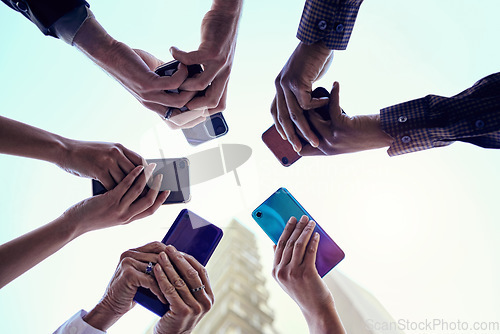 Image of Business people, hands and circle with phone, connectivity and social media in the city. Below, sky and group with hands holding mobile in urban town with internet, web and career app with diversity