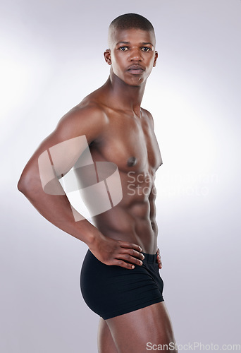 Image of Attractive, confidence and portrait of a shirtless man in a studio with a muscular body in underwear. Serious, fitness and young African male model with a strong and sexy figure by white background.