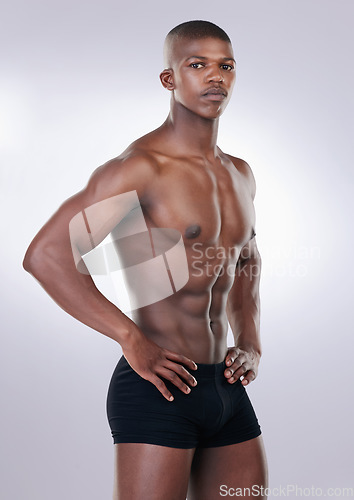 Image of Handsome, shirtless and portrait of a man in a studio with a muscular body in underwear. Serious, fitness and young African male model with a strong, sexy and attractive figure by white background.