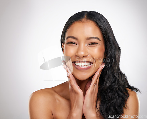 Image of Hair, beauty and hands on face of happy woman in studio for cosmetics, treatment and shine on grey background. Smile, portrait and haircare for female model with volume, texture and keratin results