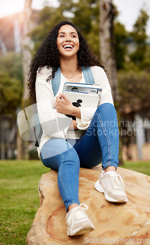 Image of Park, university and woman with book on campus for learning, knowledge and studying on rock. Education, school and happy female student laugh with textbook for information, research or college lesson