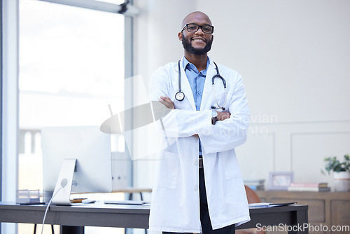 Image of Doctor office, black man and portrait with arms crossed at a hospital with healthcare and wellness success. Face, happiness and medical employee with African male professional feeling proud from job