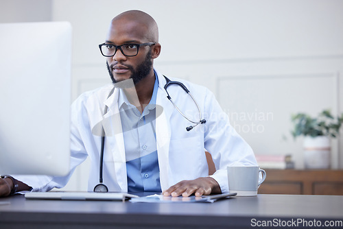Image of Black man, serious doctor and computer focus with medical and healthcare research in office. Wellness, hospital and clinic data reading of a African male professional working on tech for health