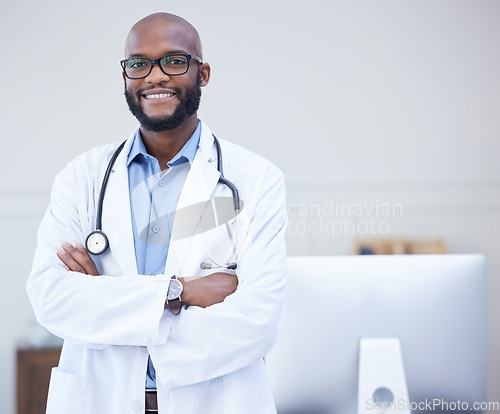 Image of Doctor, black man and portrait with arms crossed at a hospital with healthcare and wellness success. Face, happiness and medical employee with a African male professional feeling proud with mockup