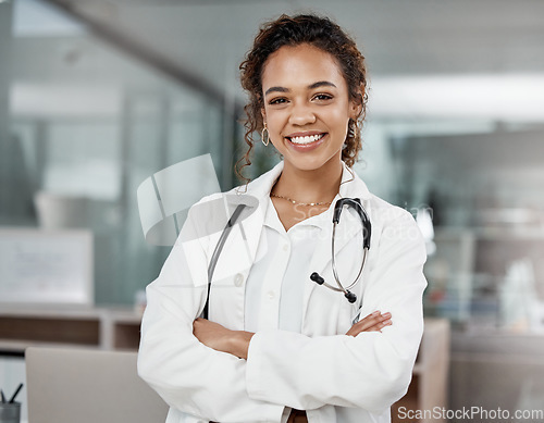 Image of Healthcare, portrait of woman doctor with arms crossed and with stethoscope in a hospital building happy with a lens flare. Medical, wellness and female surgeon or nurse smile excited in a clinic