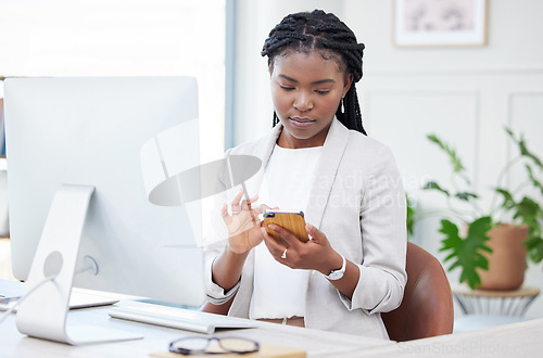 Image of Black woman, business and typing on phone at a desk for communication, chat and social media. Serious african female entrepreneur reading email on smartphone app with network connection