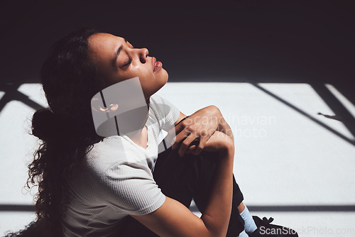 Image of Mental health, sad woman sitting and isolated in room with tears on her face. Anxiety or depression, psychology or trauma patient and insomnia or depressed scared young female person sit alone