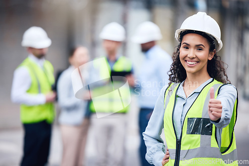 Image of Thumbs up, woman architect and at a building site happy with her colleagues in the background. Thank you or agreement, engineer and cheerful or excited construction worker at industrial workplace