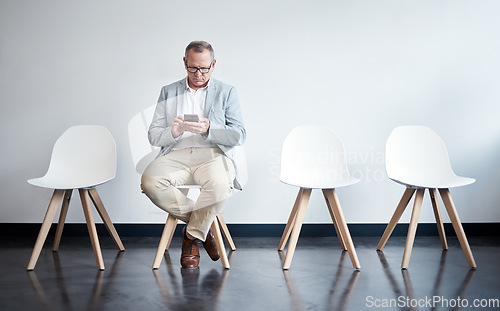 Image of Phone, hiring and business man in waiting room for job interview, networking and recruitment. Mobile, internet and technology on chair with senior male employee for career, contact or hr consultation