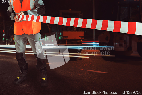 Image of Worker blocks repair street.