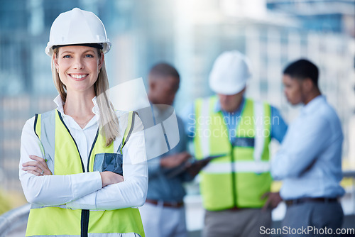 Image of Portrait, arms crossed and a woman construction worker outdoor on a building site with her team in the background. Management, leadership and confidence with a female architect standing outside