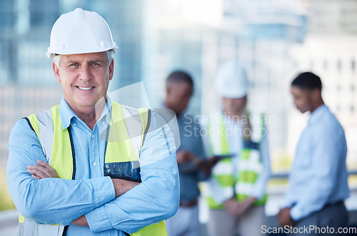 Image of Portrait, arms crossed and a senior man construction worker outdoor on a building site with his team in the background. Management, leadership and confidence with a mature male architect outside