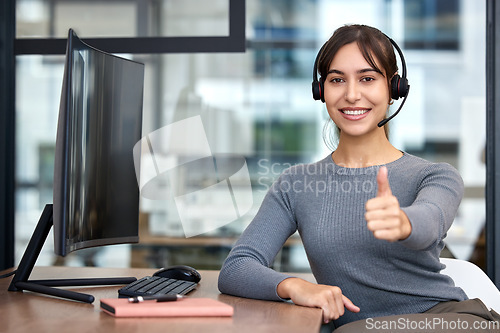 Image of Thumbs, woman with headset and on a computer at her desk in a workplace office for success. Call center or customer service, crm and online communication with female person for support at her work