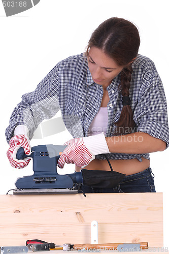 Image of woman carpenter at work, sander