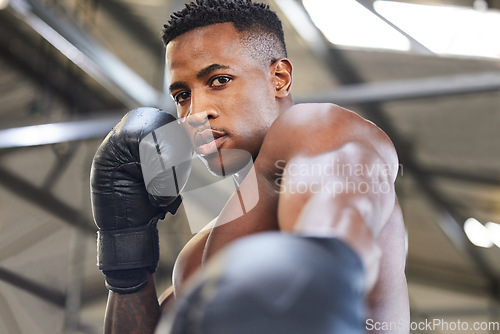 Image of African man, boxing and punch in portrait for fitness, focus or training at gym for growth, goal and competition. African guy, boxer and gloves for exercise, wellness and martial arts club for sports