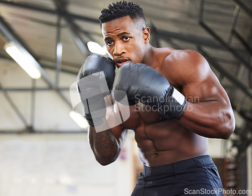 Image of African man, boxing and punch in gym for fitness, focus or training for growth, goal and wellness for competition. African guy, boxer and gloves for exercise, wellness or martial arts club for sports