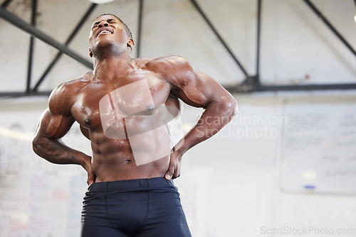 Image of Fitness, muscle and tired with a black man bodybuilder breathing in the gym, exhausted after a workout. Exercise, fatigue and sweat with a strong, shirtless male athlete taking a break from training