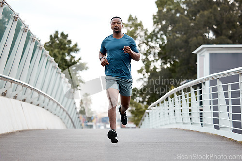 Image of Black man, fitness and running on bridge in city for cardio exercise, workout or training outdoors. Fit, active and sporty African male person, athlete or runner exercising on a run in an urban town