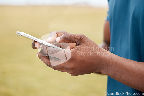 Image of Man, hands and phone for social media, communication or networking in sports on grass field outdoors. Hand of male person or athlete chatting, typing or texting on mobile smartphone app in nature