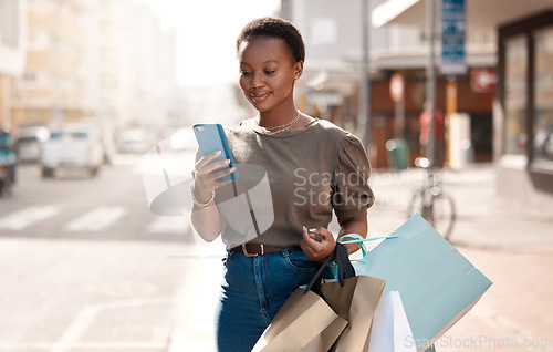 Image of Shopping, bag and phone with black woman in city for social media, networking and communication. Fashion, retail and luxury with female customer in Nigeria Town for contact, ecommerce app and sale